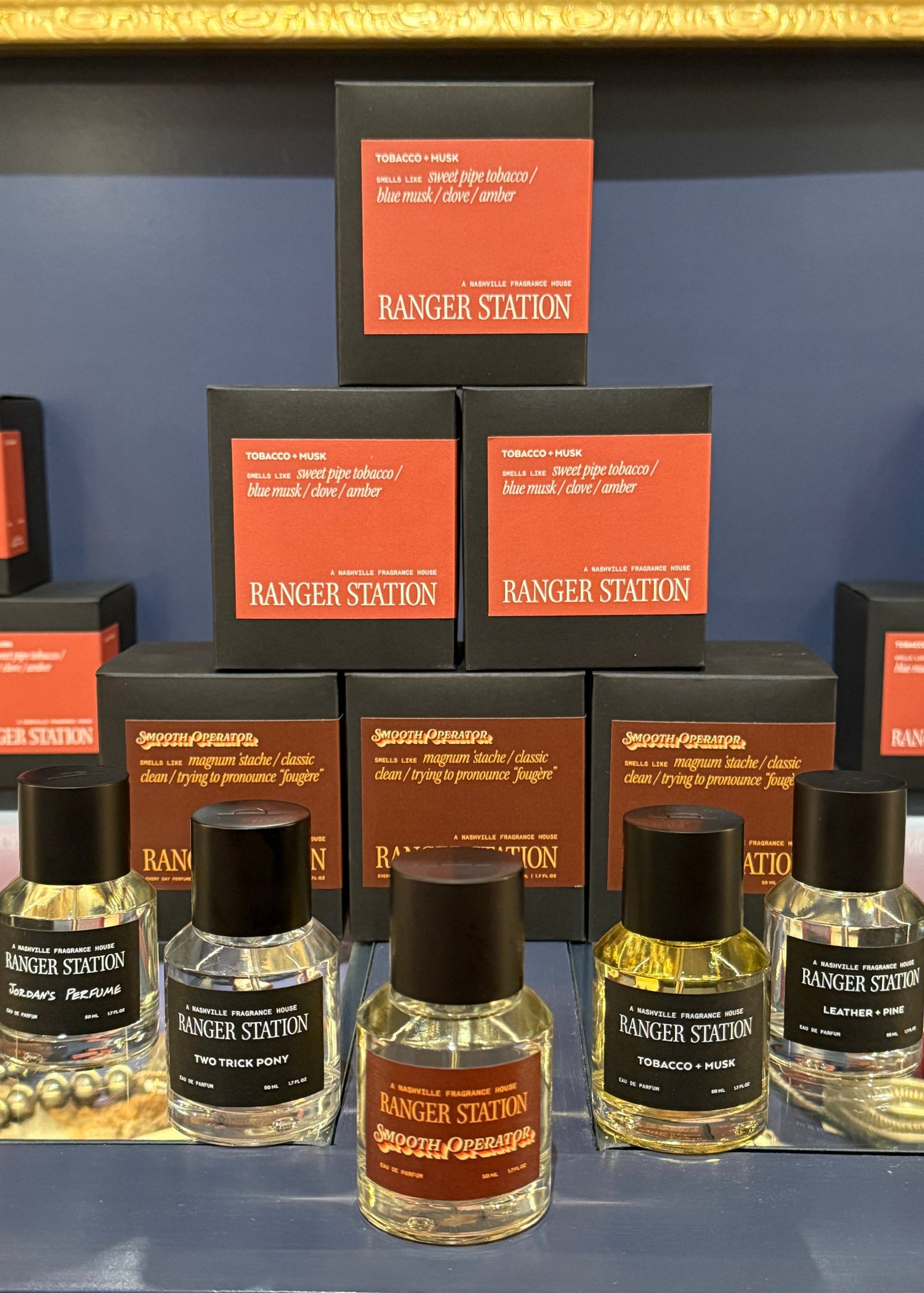 Several Ranger Station scented tobacco products displayed on a shelf, including small clear bottles with black caps and black boxes featuring orange labels. The brand name RANGER STATION is clearly visible on multiple items.